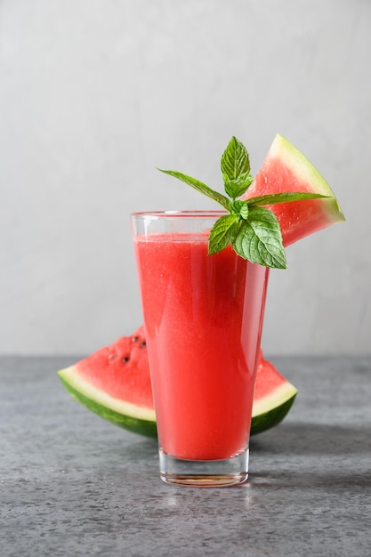 Glas Wassermelonencocktail garniert Minze auf grauem Hintergrund Nahaufnahme