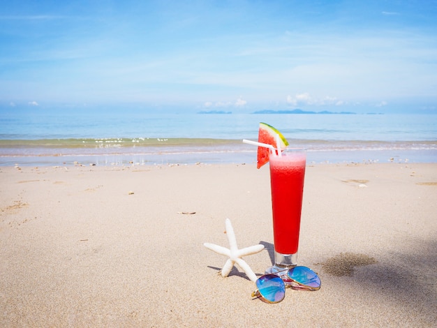 Glas Wassermelonensaft auf Sommerstrand