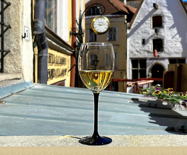 Glas Wein und Tasse Kaffee und Kerze auf Straßencafé-Tisch in der mittelalterlichen Altstadt von Tallinn