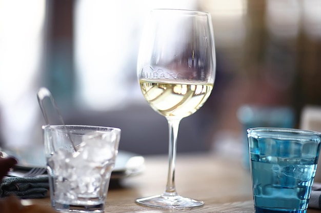 Glas Weißwein im Restaurant / Weißwein im Inneren des Restaurants ein Tisch mit Gläsern Wein, ein romantischer Sommer