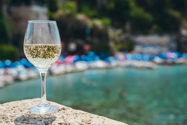 Glas Weißwein vor dem Hintergrund des Mittelmeerstrandes