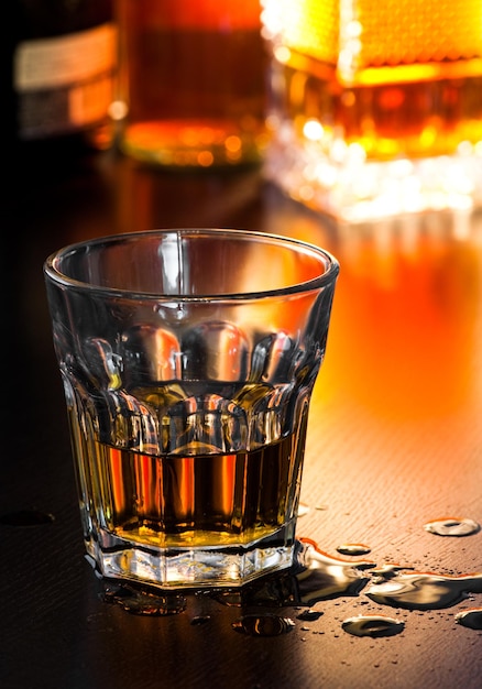 Glas Whiskey auf dem Tisch mit Tropfen flacher DOF