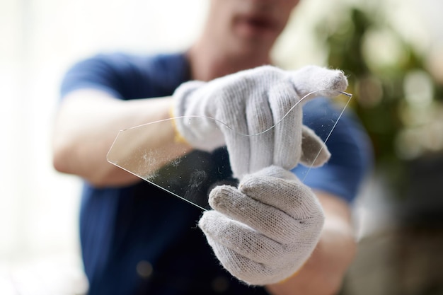 Glasarbeiter zeigt geschliffenes Glas in der Werkstatt