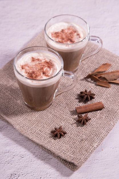 Glasbecher mit indischem Tee Masala-Tee mit Milch und Gewürzen auf einer Serviette, Nahaufnahme. Platz kopieren