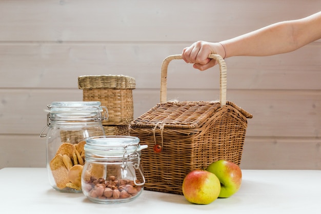 Glasdosen mit Nüssen und Keksen und Äpfeln auf Holztisch Null Abfall Picknick-Konzept