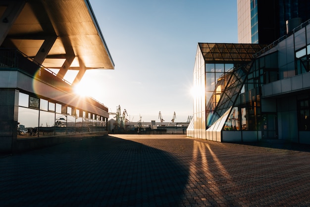 Glasgebäude im Abendsonnenlicht vor dem Hintergrund des Seehafens