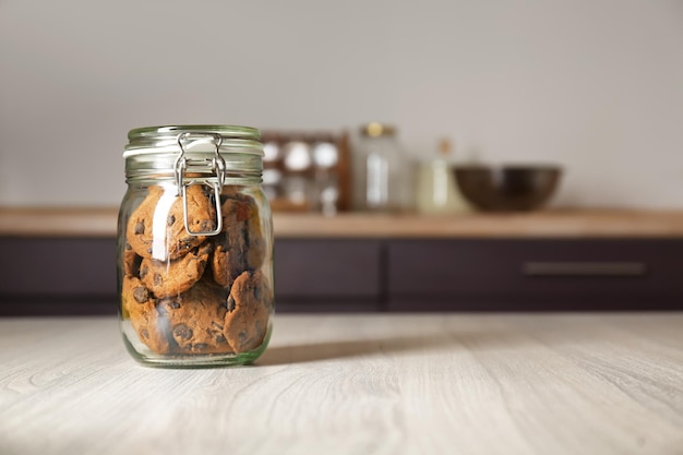 Glasgefäß mit köstlichen Haferkeksen auf Holztisch