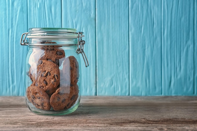 Glasgefäß mit köstlichen Haferkeksen auf Holztisch