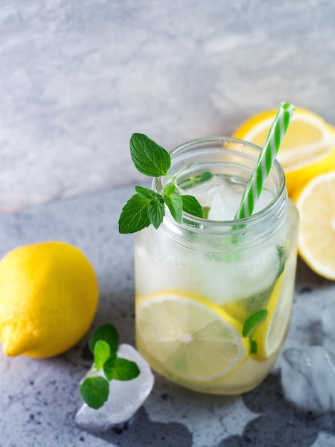 Foto glasgefäß mit sommerlich erfrischender mojito-limonade mit zitronenminze und eis