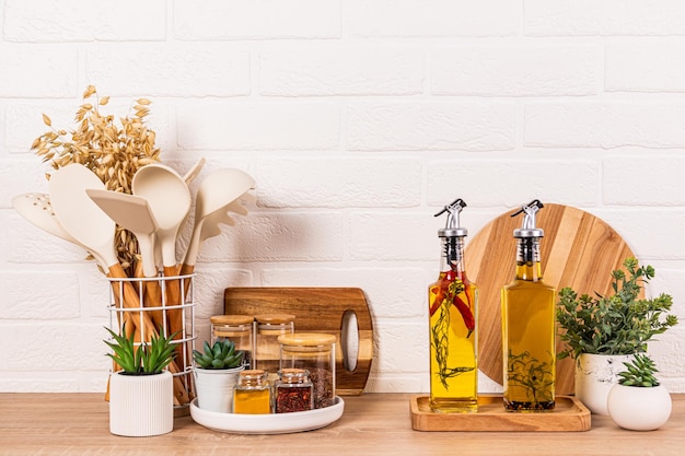 Glasgläser mit Gewürzen und Gewürzen, stilvolle Ölflaschen in der Küche, Schneidbretter aus Holz, Ideen für das Innere der Küche