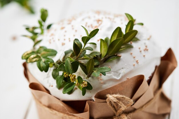 Glasierter Osterkuchen auf weißem hölzernem Hintergrund, traditionelles Kulich, Paska bereit zum Feiern