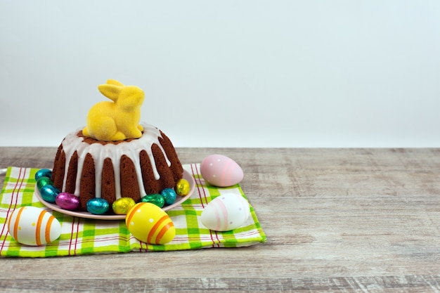 Glasierter Osterkuchen, verziert mit Eiern und gelbem Hasen