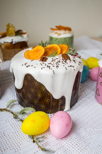 Glasierter Osterkuchen, verziert mit Orangen und Eiern auf Holztisch Frohe Osterferien