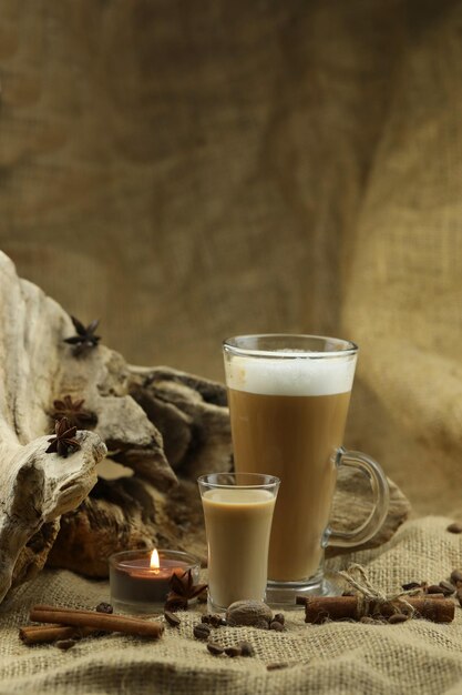 Glaskaffee mit einem Glas irischem Sahnelikör und Gewürzen Stoffhintergrund mit Kopierraum