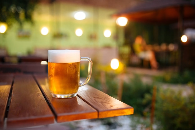 Glaskrug frisches kaltes Bier in der Sommerterrasse