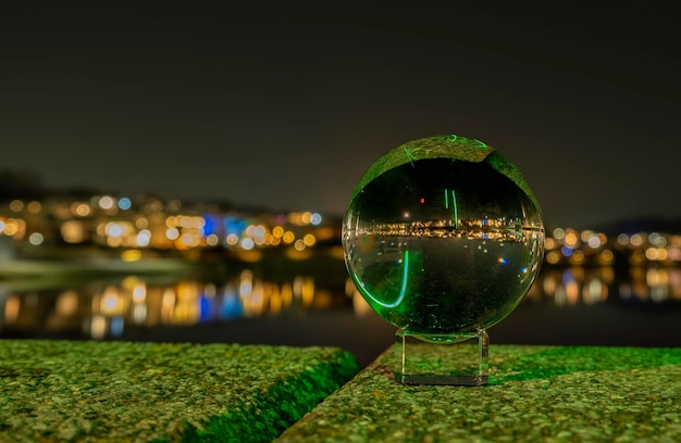 Glaskugel mit einem grünen Ball auf dem Fluss