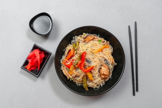 Glasnudeln mit gemüse in einer schwarzen schüssel auf grauem hintergrund asiatisches essen asiatische küche asiatisch oder s