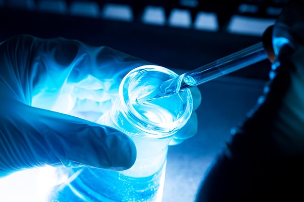 Glasrohr für blaue Wissenschaftsexperimente, Forscher mit Chemie-Reagenzgläsern in einem Flüssigglaslabor für