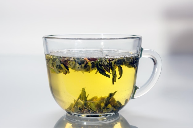 Glasschale mit grünem Tee, der sich in grauem Glas widerspiegelt