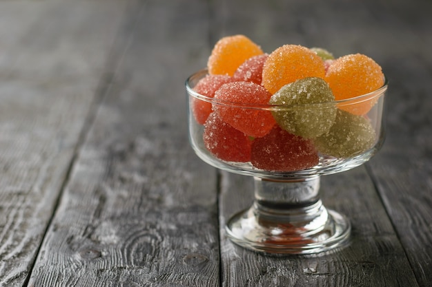 Glasschale mit Stücken hausgemachter Marmelade auf einem schwarzen Holztisch