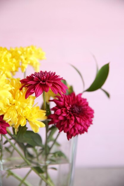 Glasvase mit schönem Blumenstrauß auf farbigem Hintergrund