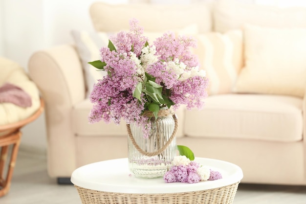 Glasvase mit schönen lila Blumen auf dem Tisch