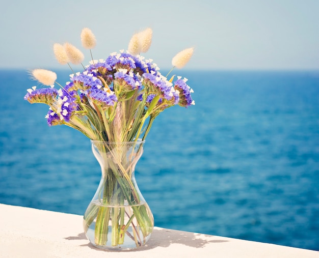 Glasvase mit Wildblumen auf dem Balkon