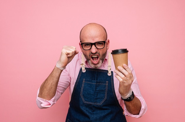 Glatze reifer Mann euphorisch mit Glück mit Kaffee in recycelbarem Pappbecher