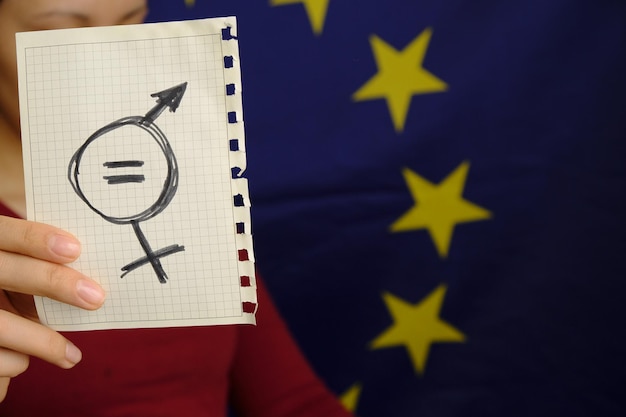 Gleichheitszeichen und ein männliches Symbol auf einem Blatt Papier, das die sexuelle Gleichstellung der Frauen darstellt