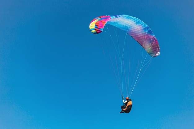 Gleitschirm am blauen Himmel Der Sportler fliegt mit einem Gleitschirm