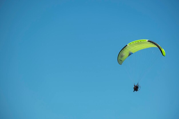 Gleitschirmfliegen am sonnigen Tag mit blauem Himmel