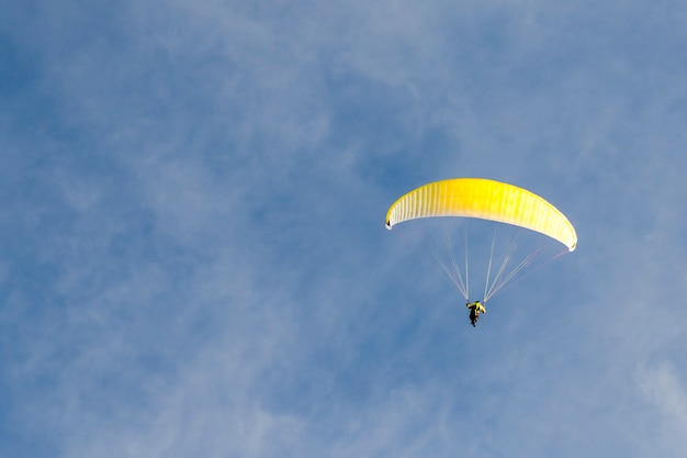 Gleitschirmfliegen im blauen Himmel