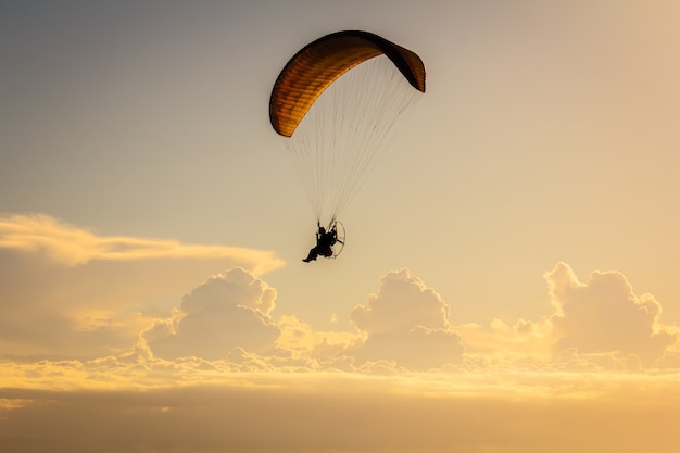 Foto gleitschirmfliegen mit dem sonnenuntergangshintergrund