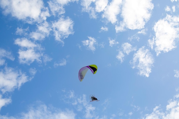 Gleitschirmflug vor dem Hintergrund des blauen Himmels