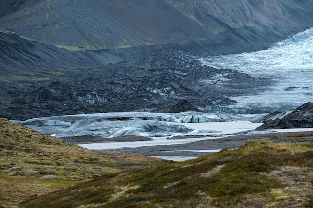 Gletscherzungenrutsche von der Vatnajokull-Eiskappe oder dem Vatna-Gletscher in der Nähe des subglazialen Oraefajokull-Vulkans Island Gletscherlagune mit Eisblöcken und umliegenden Bergen