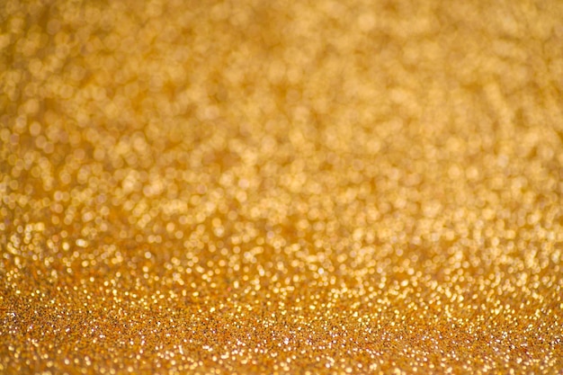 Glitter gold hintergrund textur folie und konfetti bokeh licht von goldenem staub festliche party weihnachten...