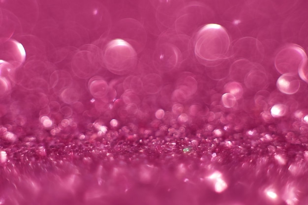 Glitter rosa, efeito desfocado. Círculos de luz brilhante do feriado são criados a partir do bokeh na câmera e na lente. Plano de fundo para o design. Fundo de Natal.