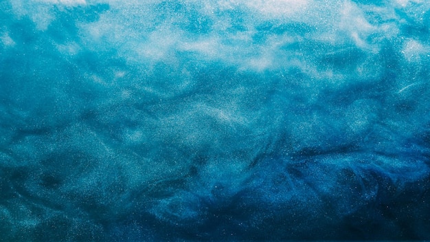 Glitterwolke Tinte Wasser Spritzer Farbe Fluss Fantasie Himmel blaue Farbe Rauch glänzende Partikel Textur Welle