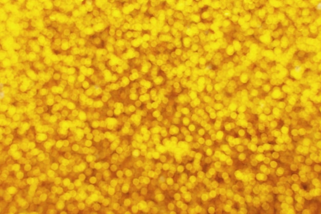 Glitzernder Hintergrund einer goldenen Paillettennahaufnahme. Funkelnde festliche Textur