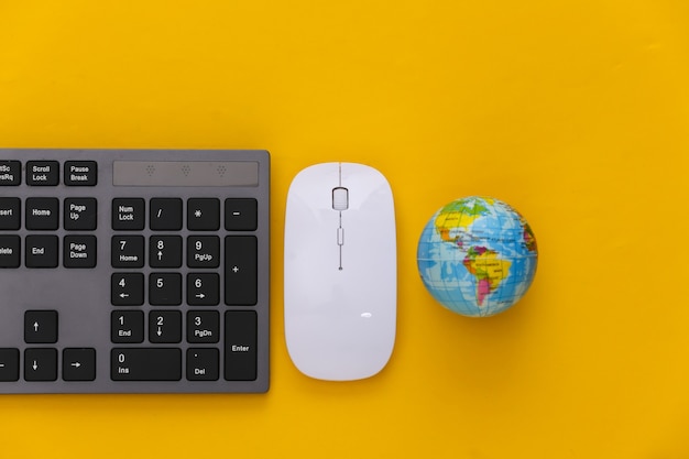 Globales Netz. PC-Tastatur mit PC-Maus, Globus auf Gelb