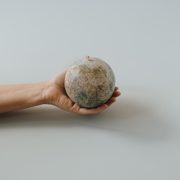 Globe-Modell in weiblicher Hand auf blauem Hintergrund Save the World Planet Earth-Konzept Frauenrechte und Machtkonzept