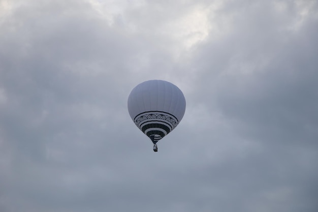 globo aerostático blanco volando al atardecer