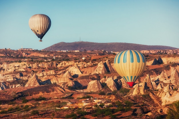 Globo aerostático volando sobre el paisaje de roca en Capadocia Turquía.