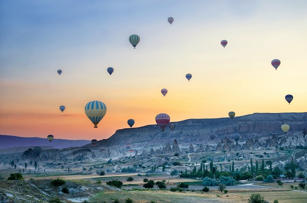 Globo aerostático volando sobre el paisaje de roca en Capadocia Turquía