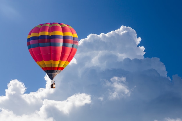 globo de aire caliente de color en el cielo azul con nubes