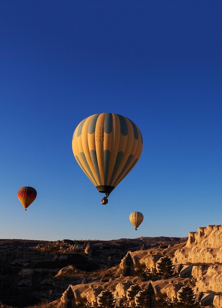 Globo de aire caliente se eleva muy alto en el cielo azul por encima de las nubes blancas brilla el sol brillante