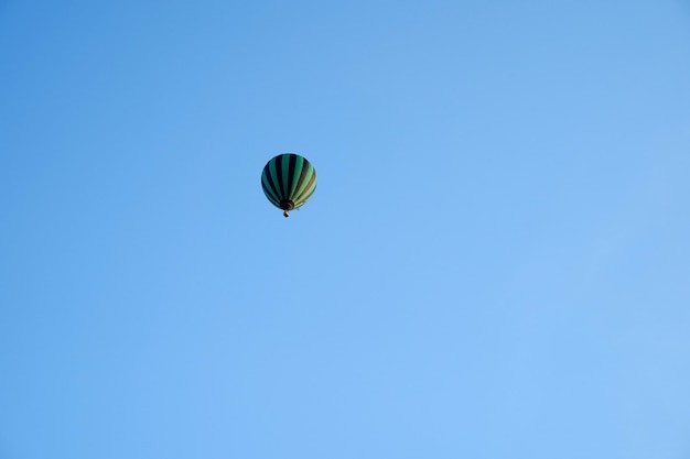 Globo de aire caliente en lo alto de un cielo azul