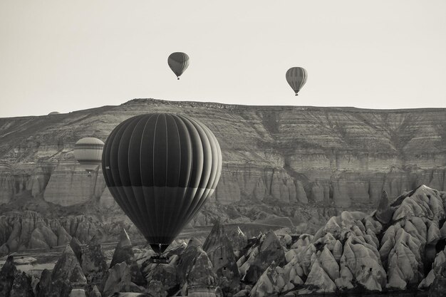 Globo de aire caliente sobrevolando el paisaje rocoso en Capadocia Turquía