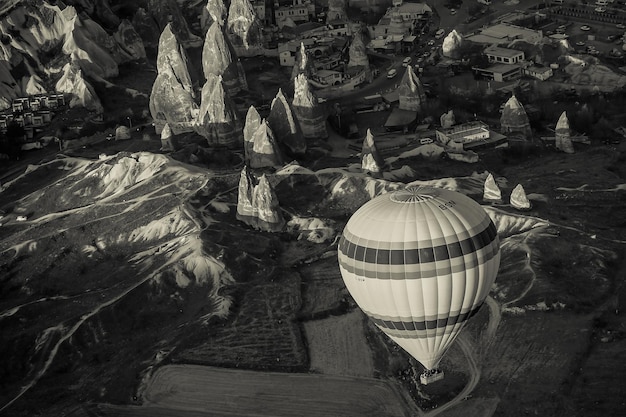 Globo de aire caliente sobrevolando el paisaje rocoso en Capadocia Turquía
