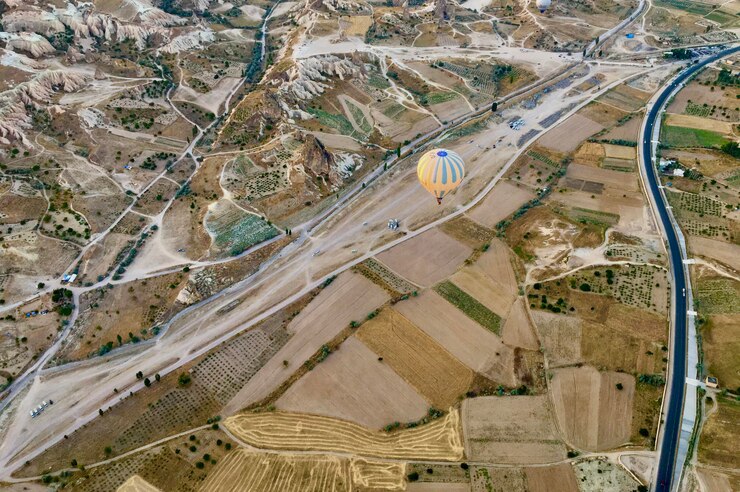 Un globo de aire caliente volando sobre un área rural